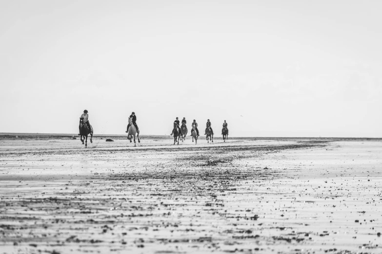 the people are riding horses on the beach