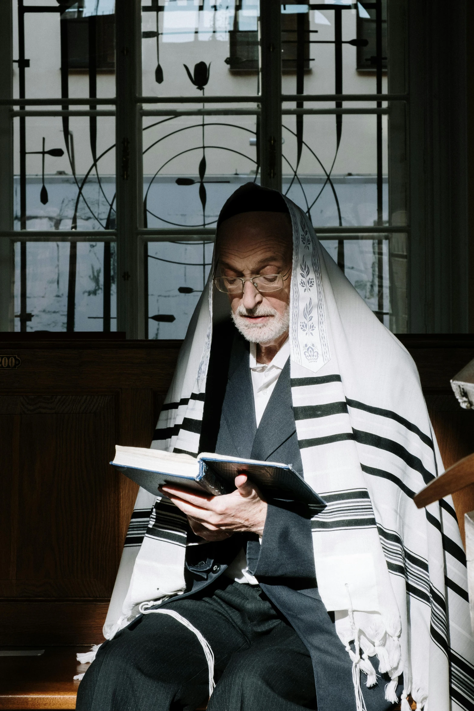 an old jewish man reading his text on his tablet