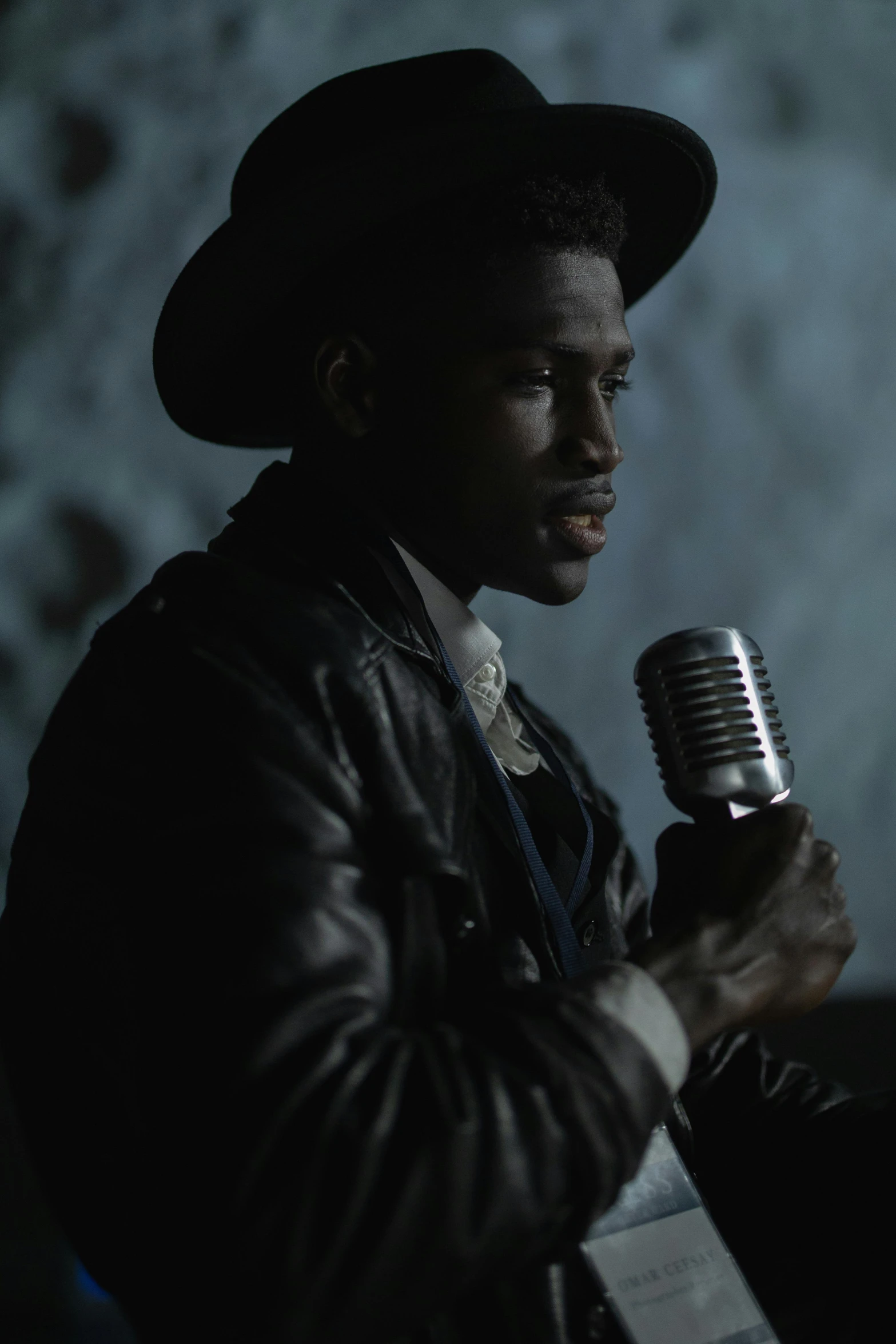 a man is holding a microphone while wearing a hat