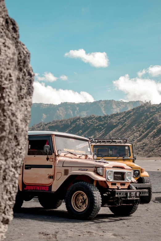 a group of vehicles parked in front of a rocky mountain