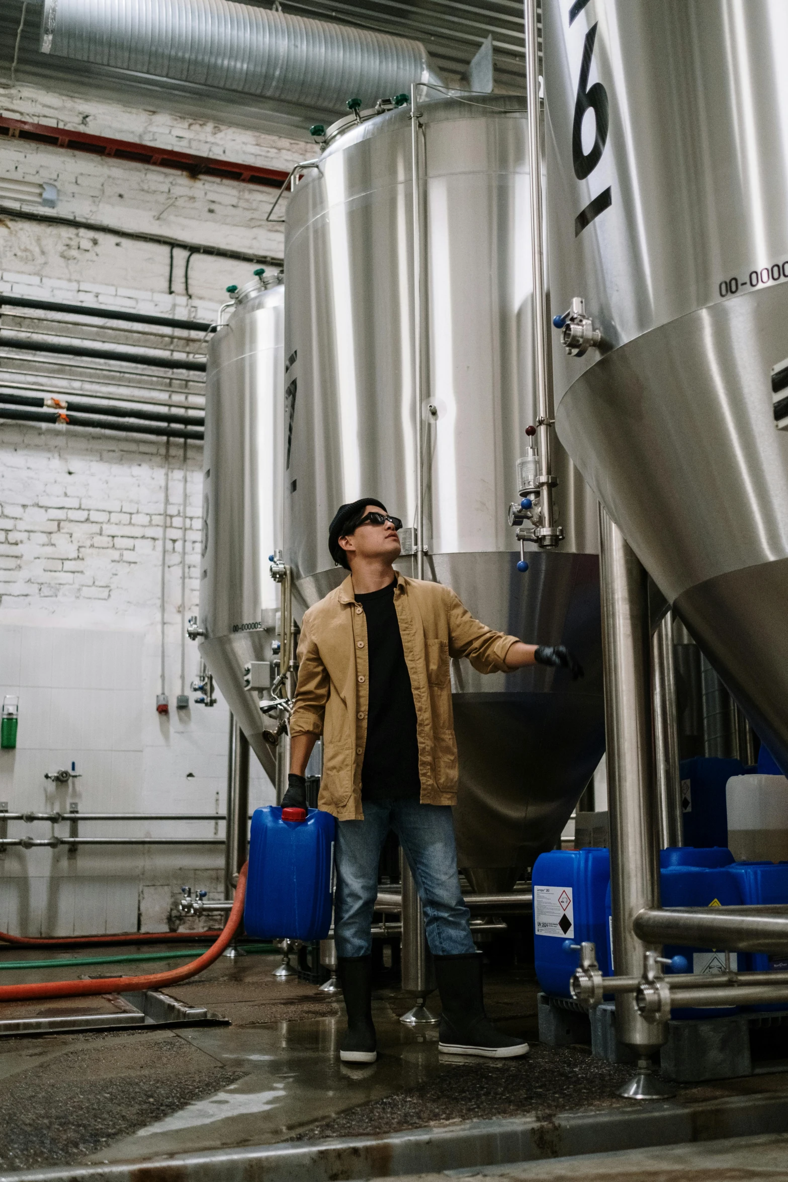 a man standing in front of some big metal tanks