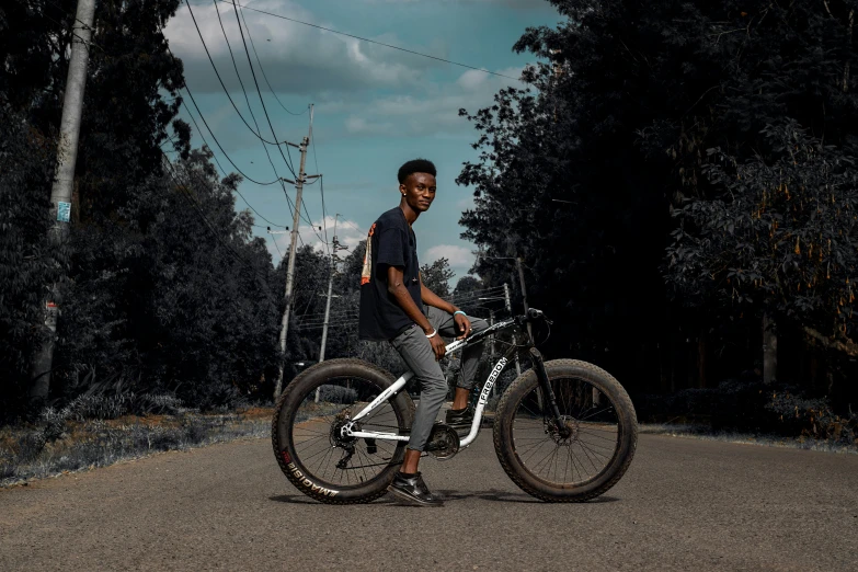a boy sitting on his bike and posing for the camera