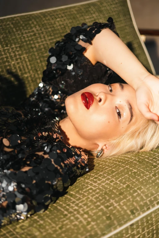 a woman laying down in a dress with a red lipstick on her lips