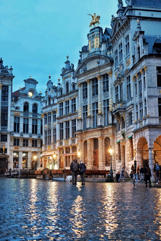 a city square with old buildings and people standing in the rain