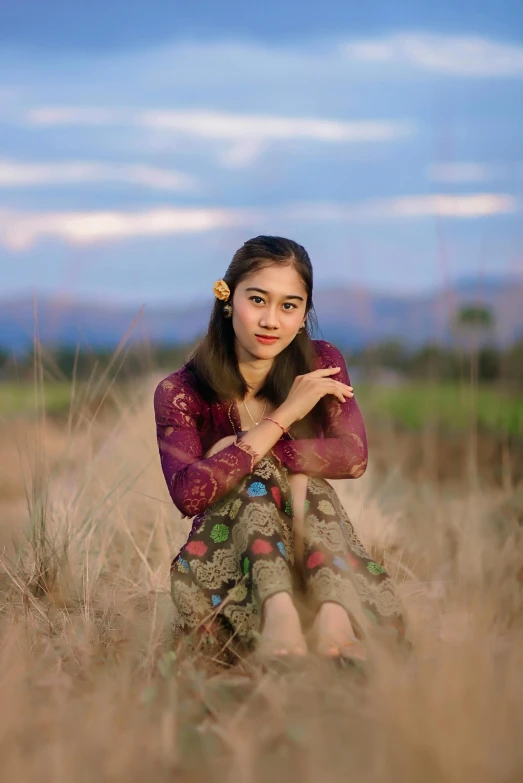 a woman sitting on the ground with her arms folded up