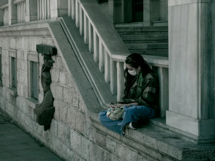 a woman sitting on the steps looking down her phone