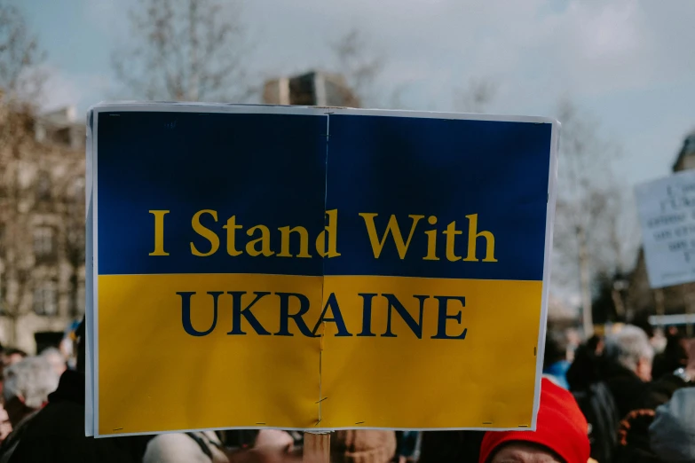 a man holding a sign at a protest on the street