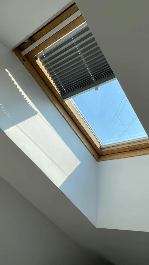 the skylight is shining into the corner of a room