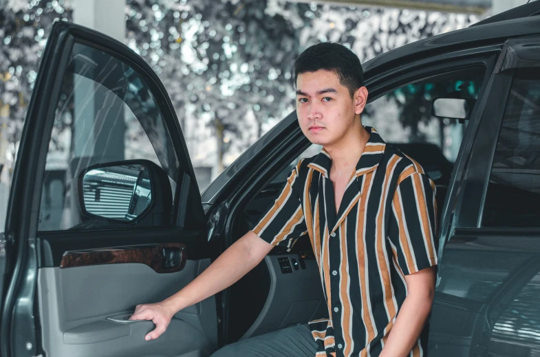 a man leaning on the door handle of his vehicle