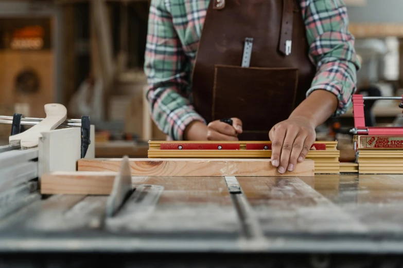 person working on wooden block at workshop area