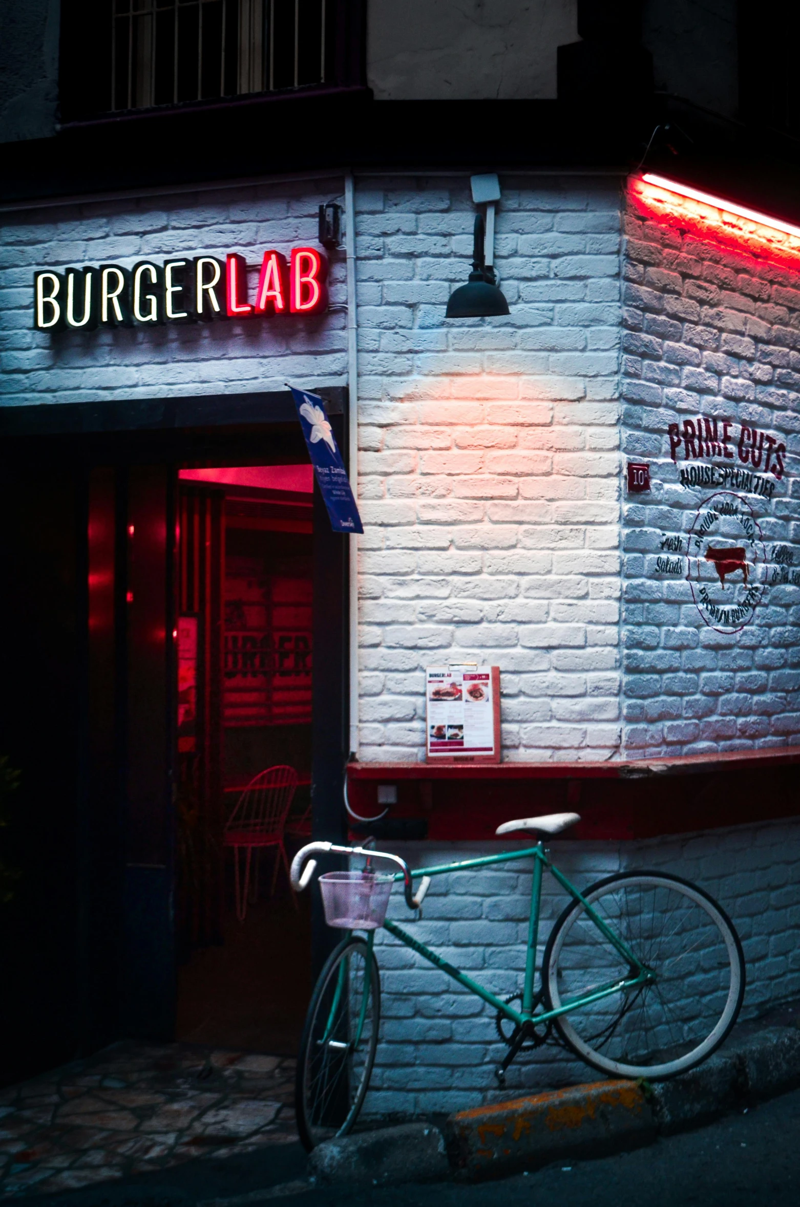 a brick building with a sign in front of it and a green bicycle parked in front