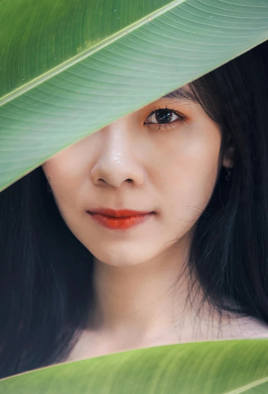 a young woman standing under a leafy tree