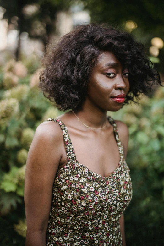 a beautiful black woman standing near bushes