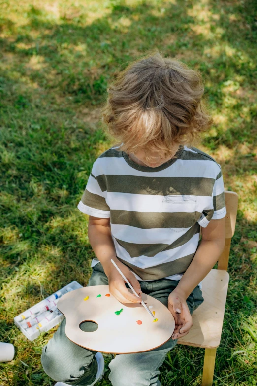 a little boy with a painting tray with different colors