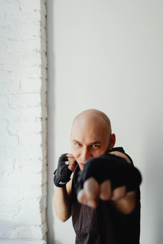 a bald headed man is pointing at the camera