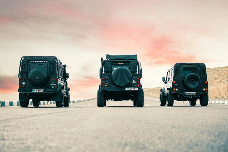 three four wheel vehicles parked in the desert