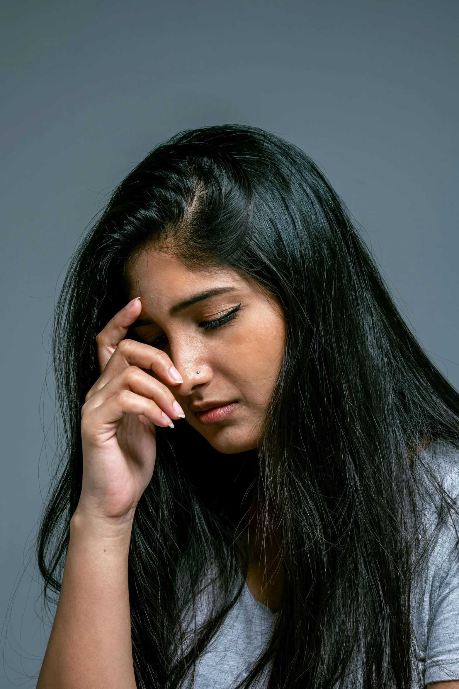 a woman is staring into the distance holding her hand up to her face