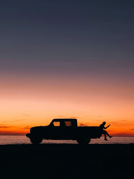 a person on the beach and the sun setting