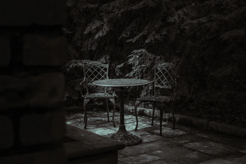 two chairs and table with an umbrella outside