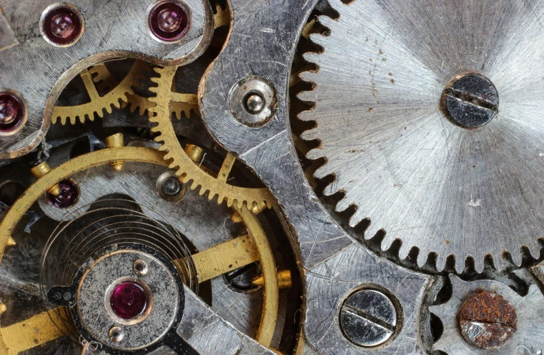 the inside of a clock with gold gears