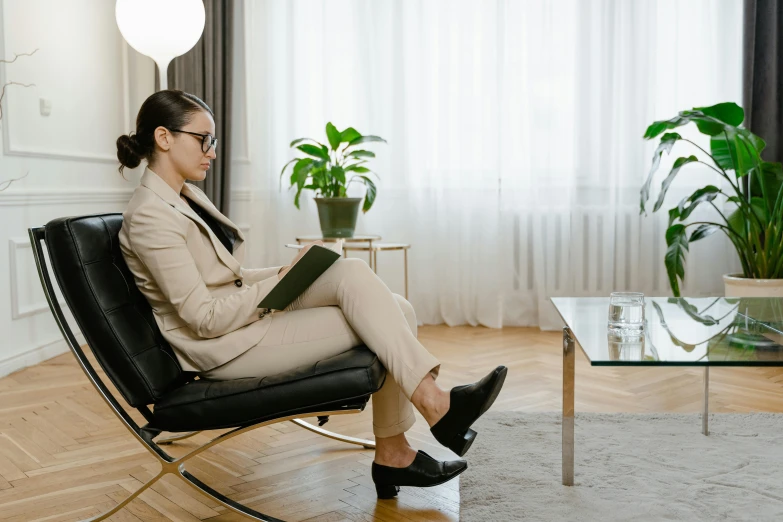 woman reading a book while sitting in a modern office