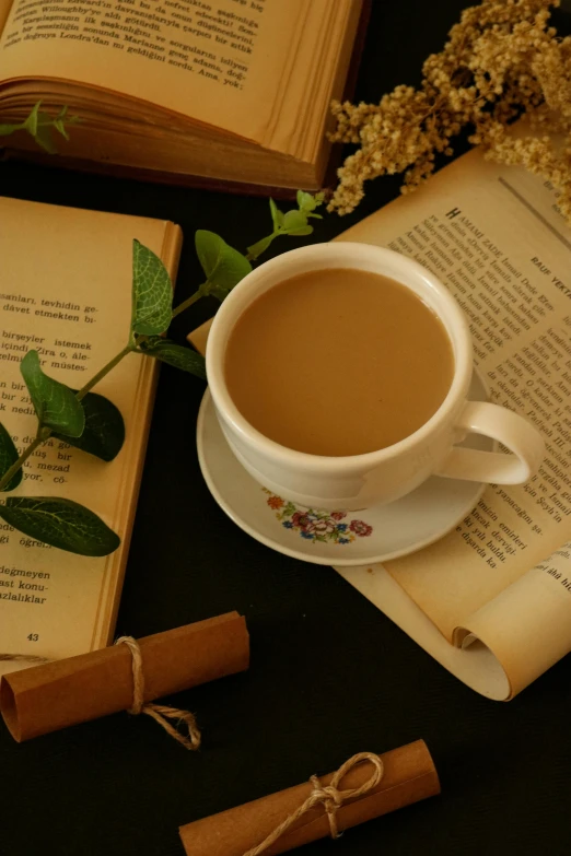 there is a cup of coffee and books on the table