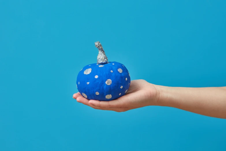 a hand holding a blue round shaped object