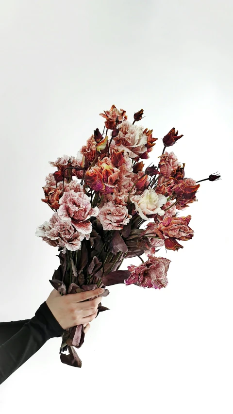 a person holding a bouquet of flowers with sky background