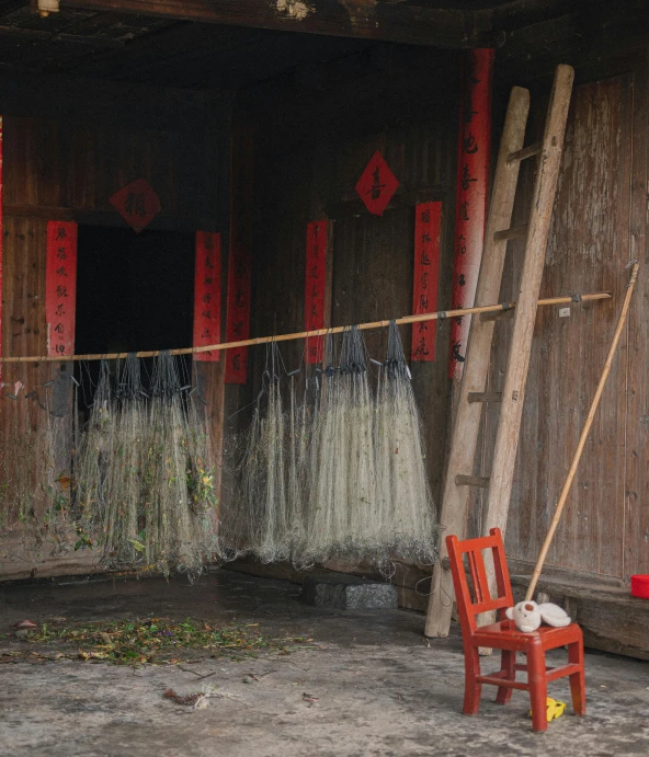 there is an asian hut with a red chair and firewood