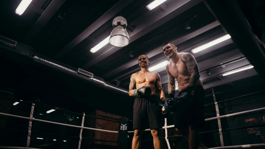 a couple of men standing next to each other in a boxing ring