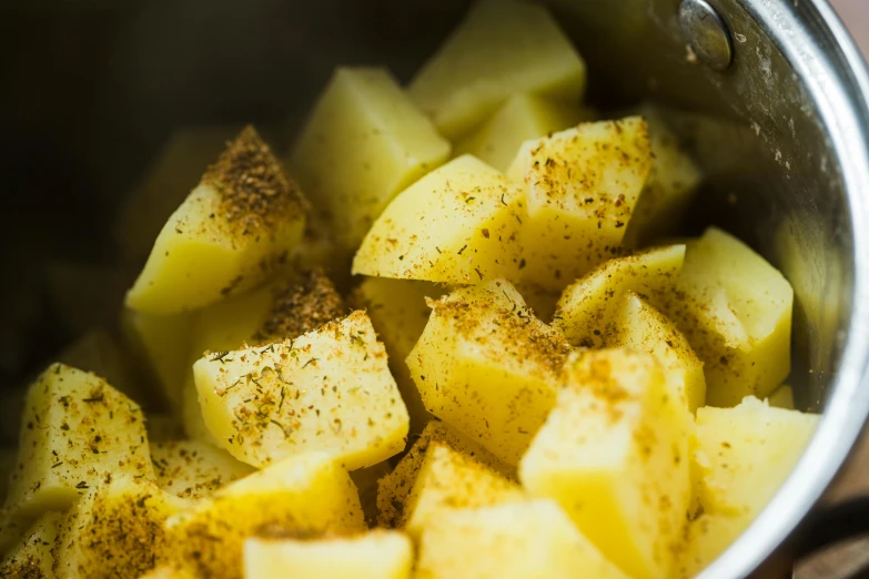 a bunch of potatoes in a pot with seasoning