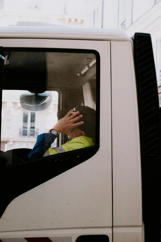 a man sitting in the driver's seat of a small truck