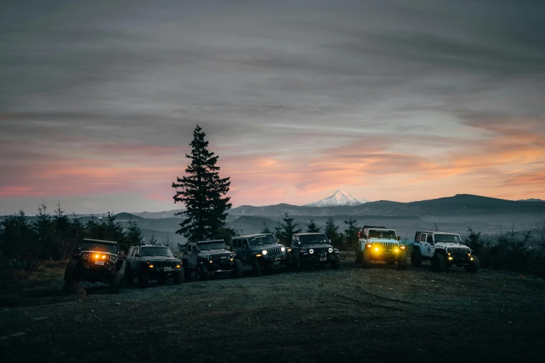 some cars parked next to each other and mountains in the distance