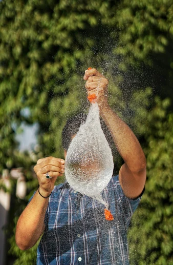 man having water sprayed all over his face