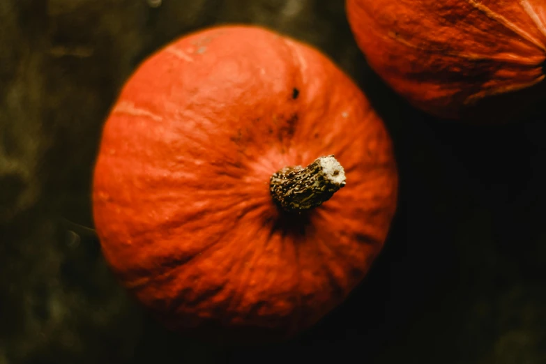 two ripe pumpkins are set out on a table