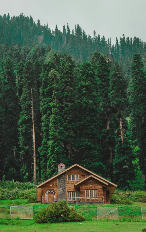 an old log cabin in the middle of a field