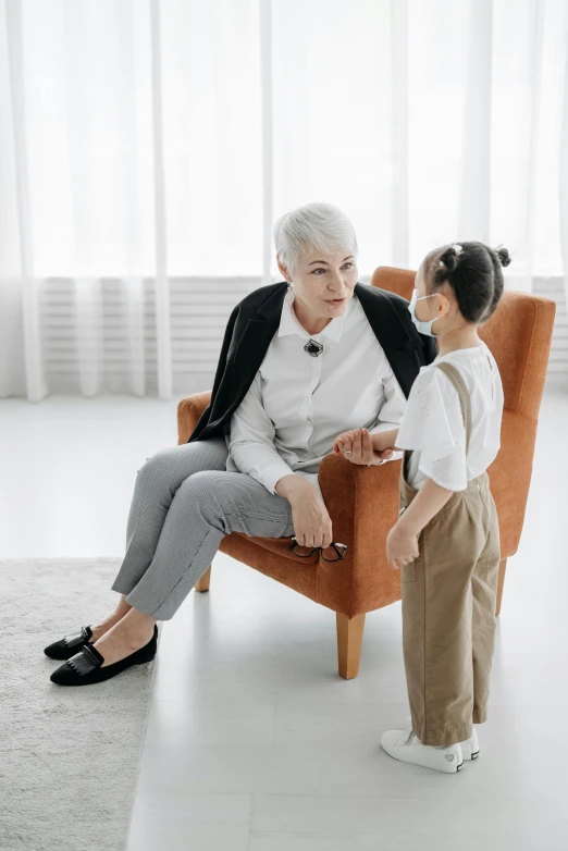 an elderly lady is sitting in the chair with her granddaughter