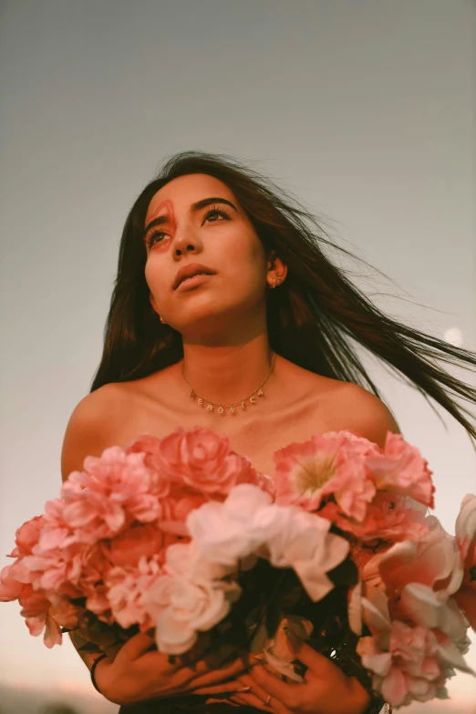 a young woman with long hair is holding flowers in her hands