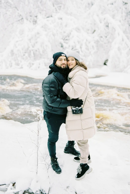 man and woman standing in the snow together