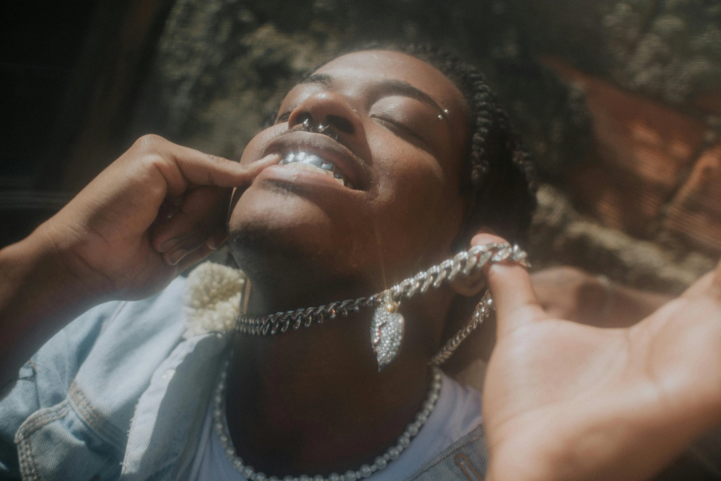 an african american woman wearing a chain around her neck, listening on a phone