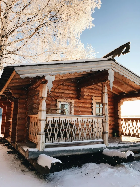 a log cabin sits on the snow, covered in snow