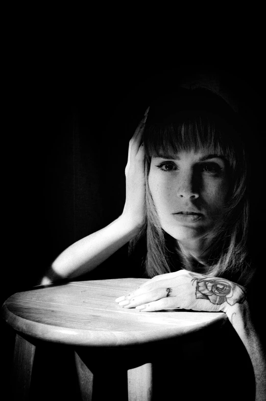 a woman sitting at a table in a black and white po