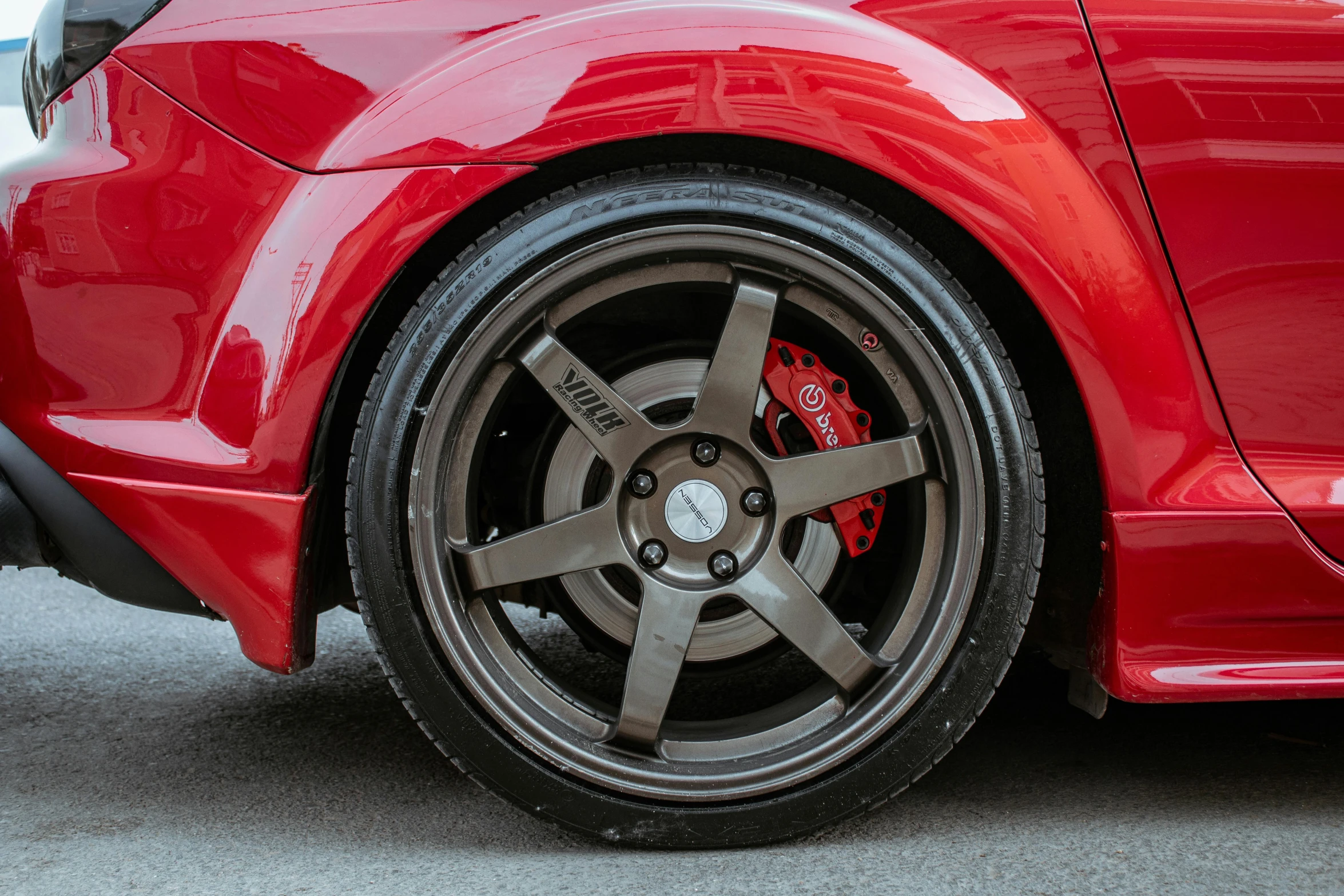 the rear wheel and tires of a red car