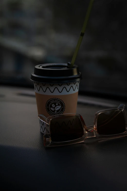 a coffee cup and sunglasses on a table