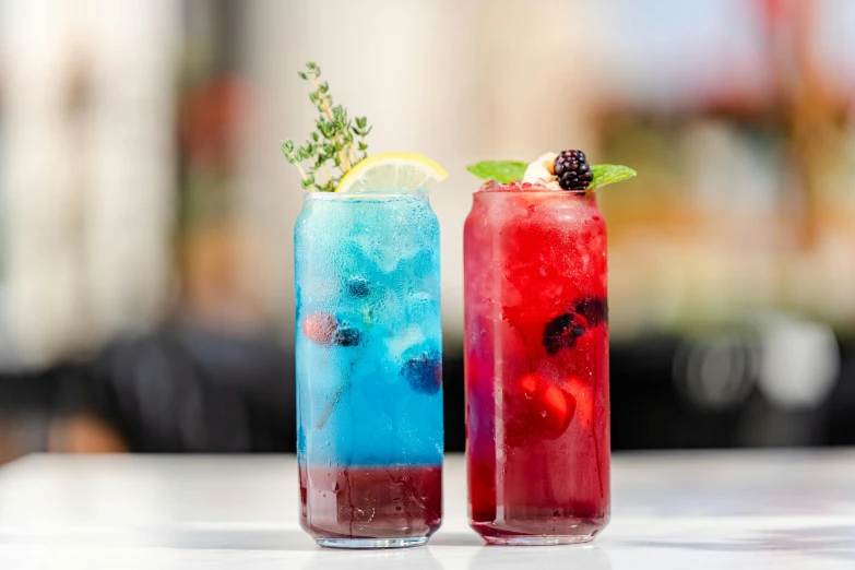 a couple of glasses filled with different colored drinks