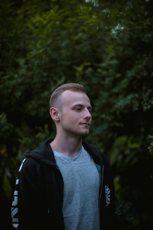 man standing in the woods looking to his left