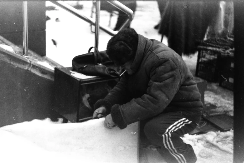 a man kneeling down with his hand near the side of a table