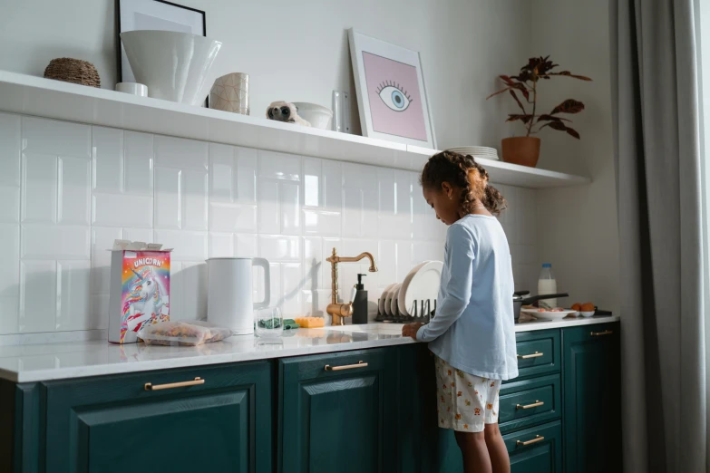 the woman is standing on the counter looking in the cabinet