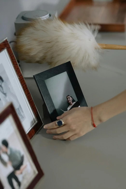 the woman is holding her hand in front of a picture