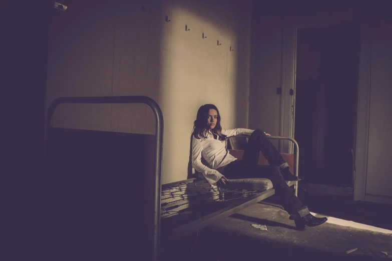 a woman sitting on a bed in an empty room